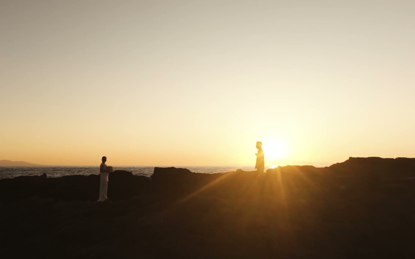 ドローンで撮影した夕日とおふたりのシルエット